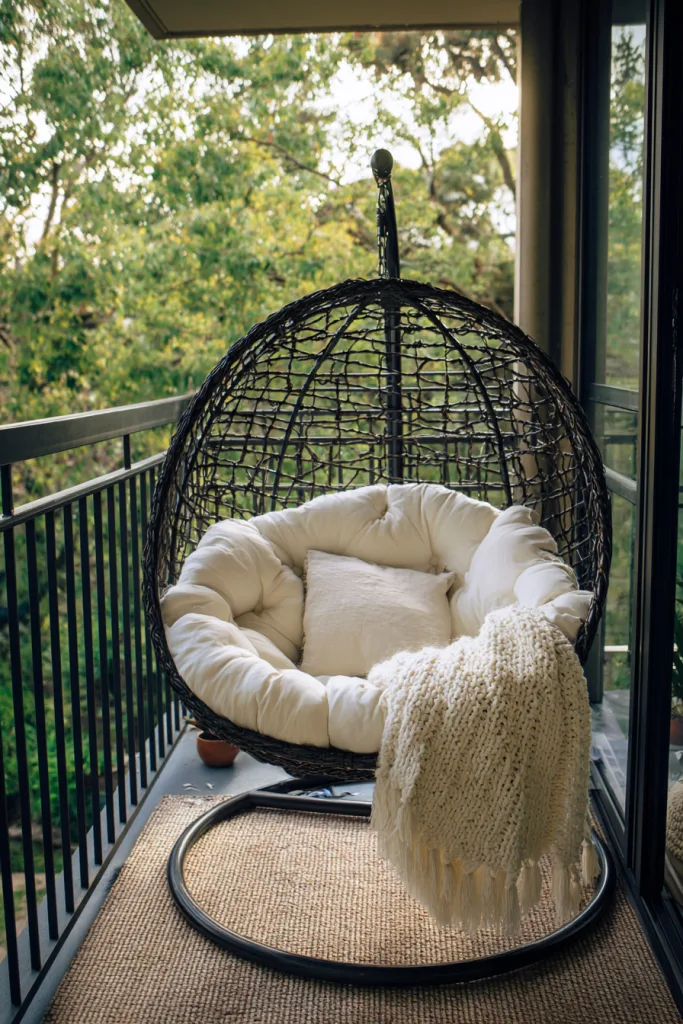 small balcony with a hanging rattan egg chair